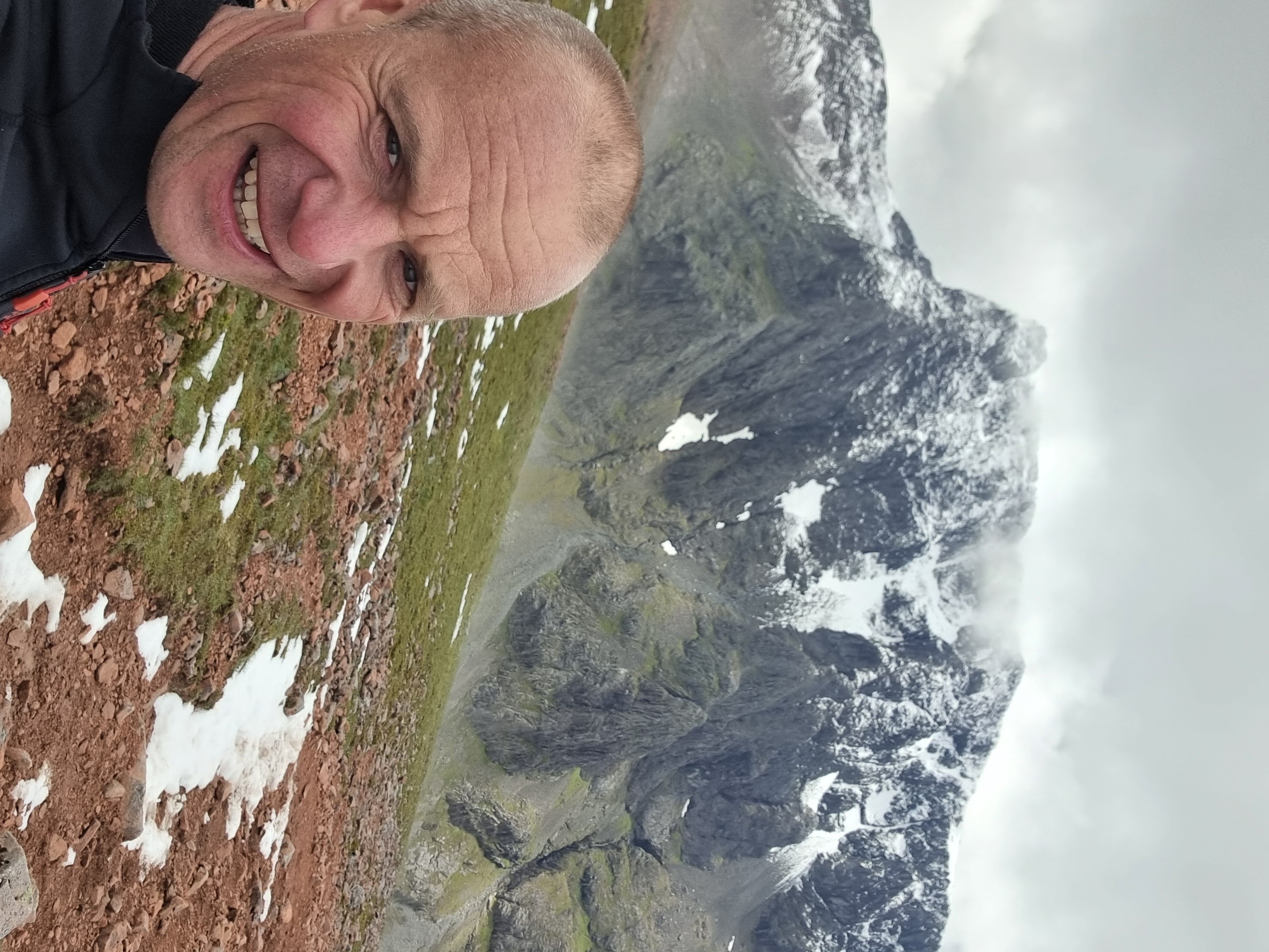 Director Sam taking a picture next to a mountain